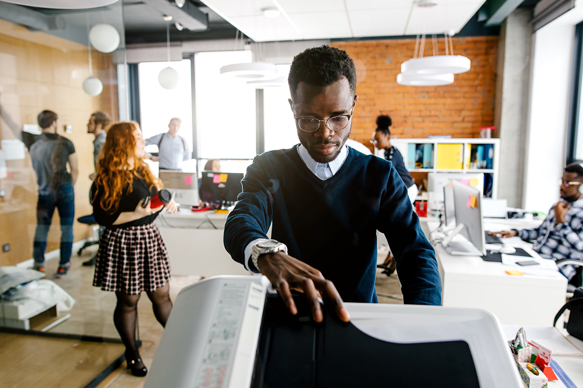 closeup portrait of black worker is printing a file , document in the office room. Accounting concept