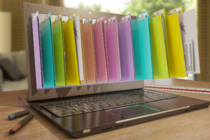 A laptop displaying colorful digital file folders emerging from the screen, symbolizing the concept of document management. This image illustrates the organization and storage of digital documents, highlighting the efficiency of document management systems in a modern workplace.